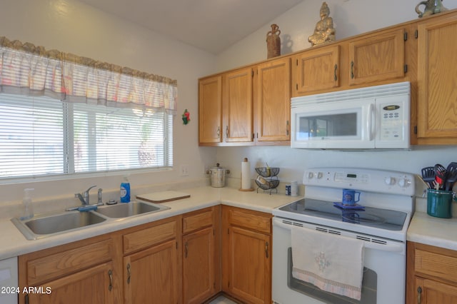 kitchen featuring sink, vaulted ceiling, and white appliances