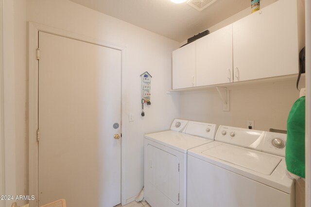 clothes washing area with independent washer and dryer and cabinets