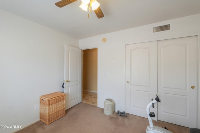 bedroom with a closet, ceiling fan, and light carpet