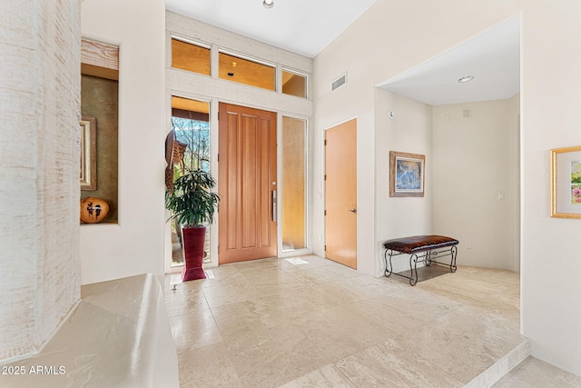 foyer with a high ceiling and visible vents