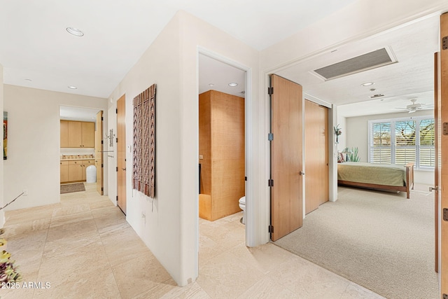 hallway with recessed lighting, visible vents, and light carpet