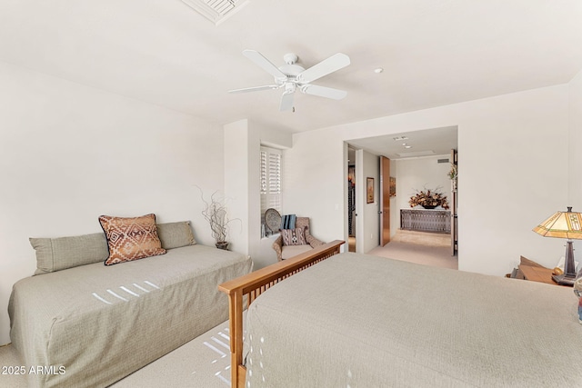 bedroom with visible vents, a ceiling fan, and light colored carpet