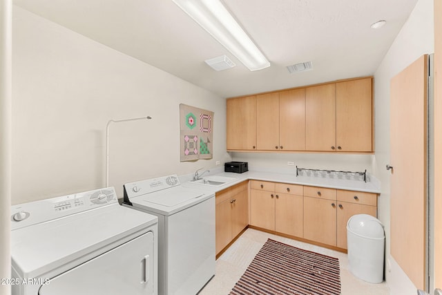 clothes washing area featuring cabinet space, washing machine and dryer, visible vents, and a sink