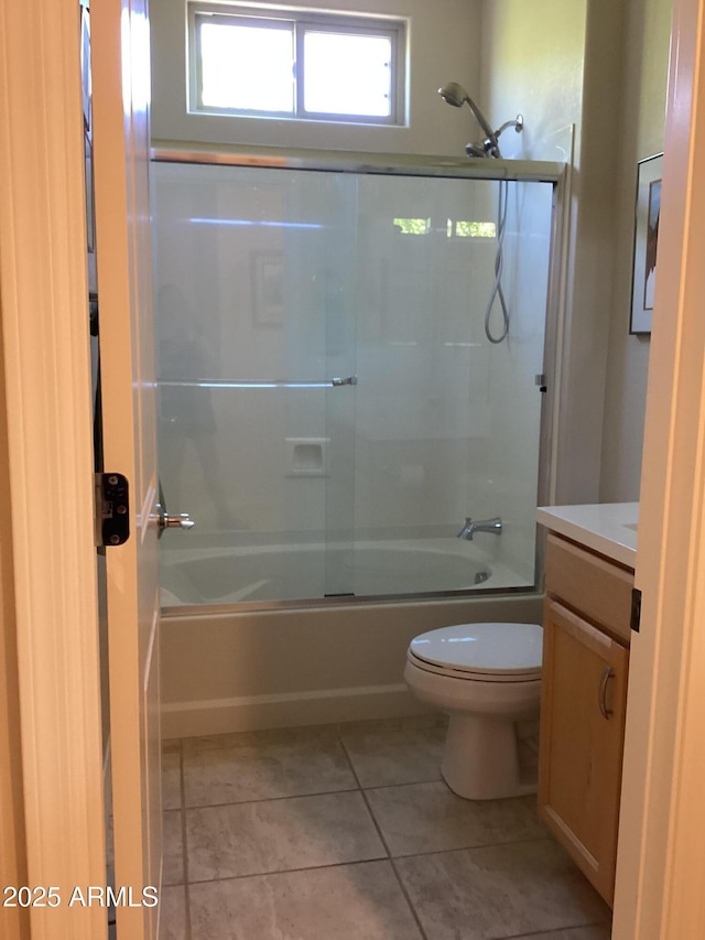 full bathroom featuring toilet, combined bath / shower with glass door, tile patterned floors, and vanity