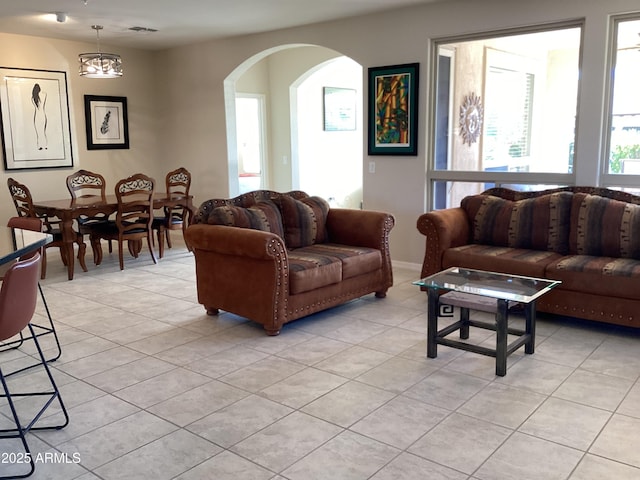 tiled living room featuring an inviting chandelier