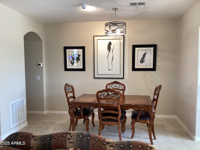 dining room with light tile patterned floors and an inviting chandelier