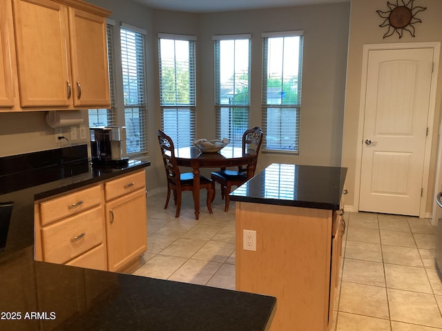 kitchen featuring light brown cabinetry, light tile patterned floors, and a center island