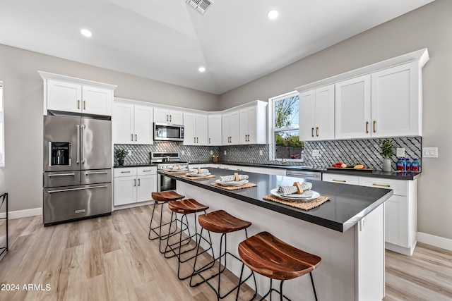 kitchen featuring white cabinets, appliances with stainless steel finishes, a center island, and light wood-type flooring