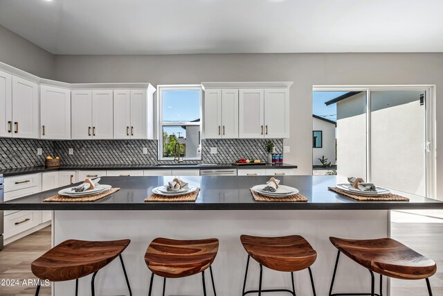 kitchen featuring light hardwood / wood-style floors, tasteful backsplash, white cabinets, and a kitchen island