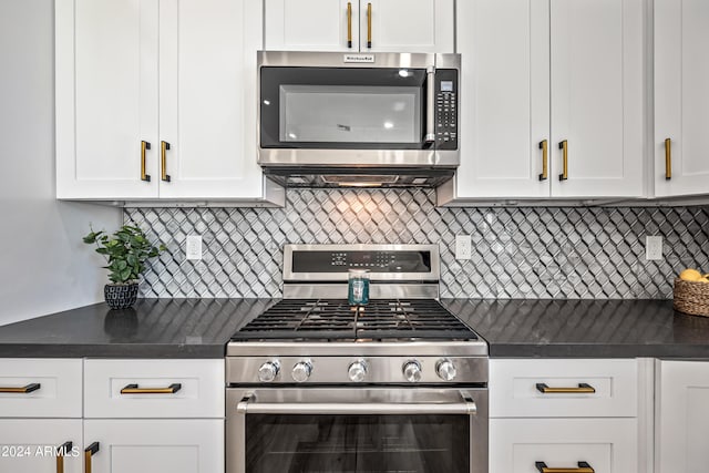 kitchen with appliances with stainless steel finishes, white cabinets, and tasteful backsplash