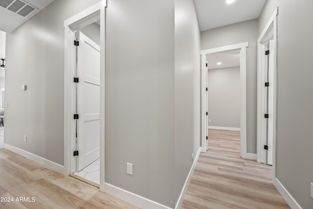 hallway with light hardwood / wood-style floors