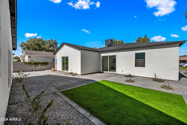 rear view of house with a yard, a patio area, and central AC unit