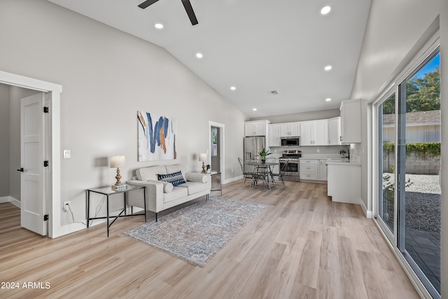 living room with high vaulted ceiling, light wood-type flooring, and ceiling fan