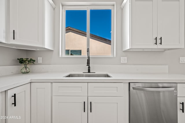 kitchen with dishwasher, sink, and white cabinetry