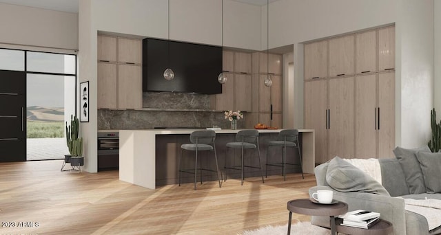 kitchen with light wood-type flooring, modern cabinets, open floor plan, a breakfast bar area, and extractor fan