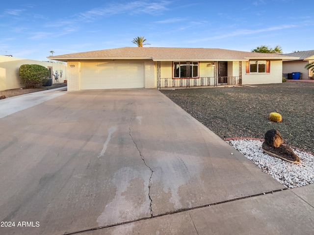 ranch-style house with a garage and covered porch