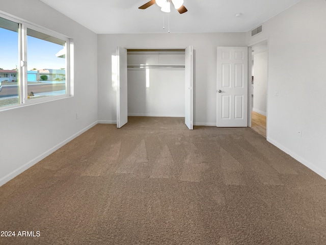 unfurnished bedroom with a closet, ceiling fan, and carpet flooring