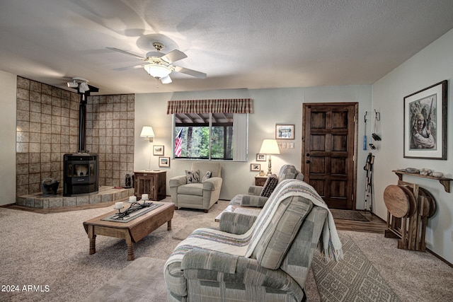 living room featuring carpet, ceiling fan, and a wood stove