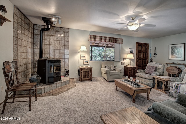 living room with ceiling fan, tile walls, a textured ceiling, a wood stove, and carpet