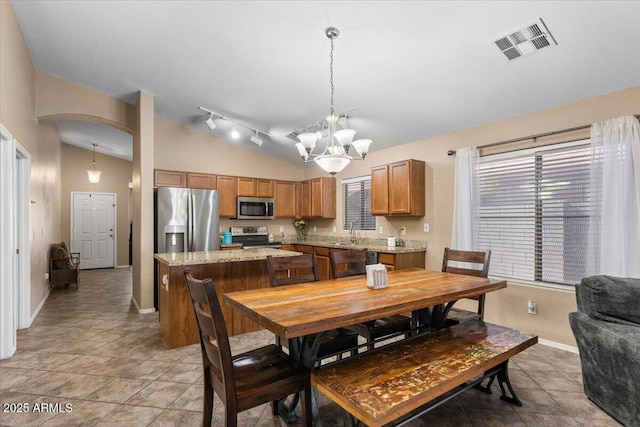 dining room featuring sink, lofted ceiling, and an inviting chandelier