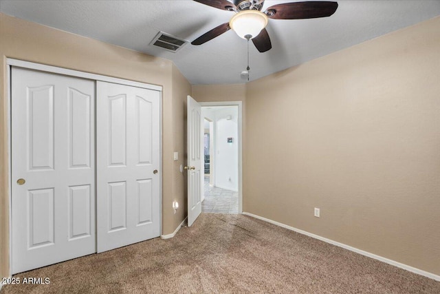 unfurnished bedroom with ceiling fan, carpet, and a closet