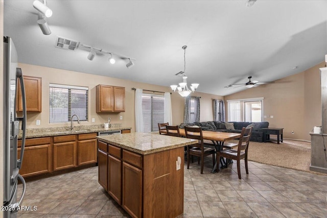 kitchen with pendant lighting, a center island, stainless steel appliances, a healthy amount of sunlight, and sink