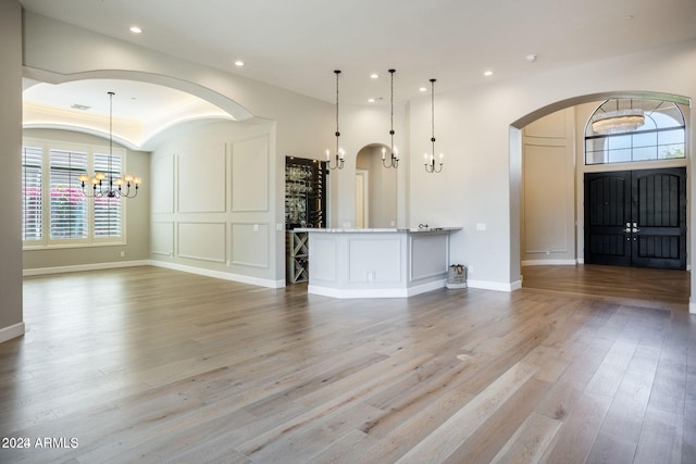 interior space featuring a chandelier, pendant lighting, and light wood-type flooring