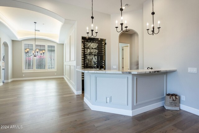 bar featuring decorative light fixtures, dark hardwood / wood-style flooring, white cabinetry, and an inviting chandelier