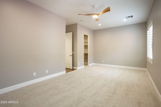 carpeted spare room featuring ceiling fan