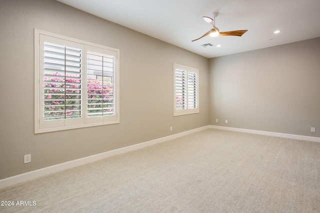 carpeted spare room with ceiling fan