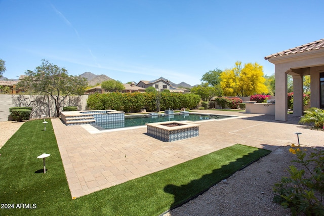 view of swimming pool featuring a mountain view, a patio area, and an in ground hot tub