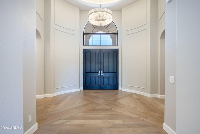 entryway featuring light parquet flooring and a notable chandelier