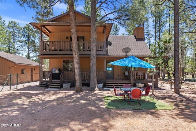 4170 Apache Dr, Happy Jack, AZ 86024 - rear view of property with a balcony, fence, a chimney, and roof with shingles