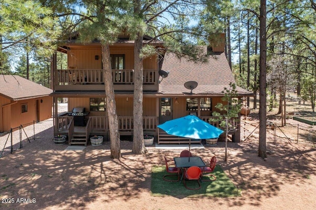 4170 Apache Dr, Happy Jack, AZ 86024 - back of property featuring a balcony, a chimney, a wooden deck, and a shingled roof