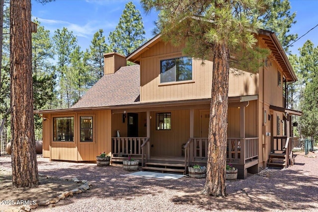 4170 Apache Dr, Happy Jack, AZ 86024 - view of front of house featuring a chimney, a porch, and a shingled roof