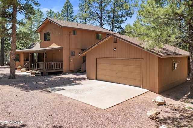 4170 Apache Dr, Happy Jack, AZ 86024 - view of front of house with concrete driveway, a porch, a shingled roof, and an attached garage