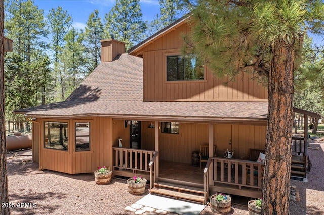 4170 Apache Dr, Happy Jack, AZ 86024 - rear view of house featuring a shingled roof, a chimney, and a porch