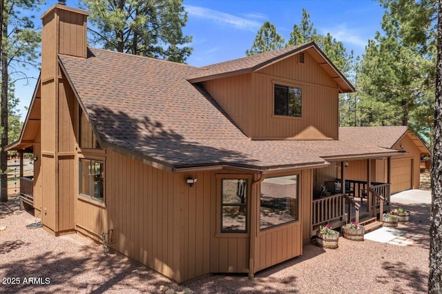 4170 Apache Dr, Happy Jack, AZ 86024 - view of front of property featuring a shingled roof, a chimney, a garage, and driveway