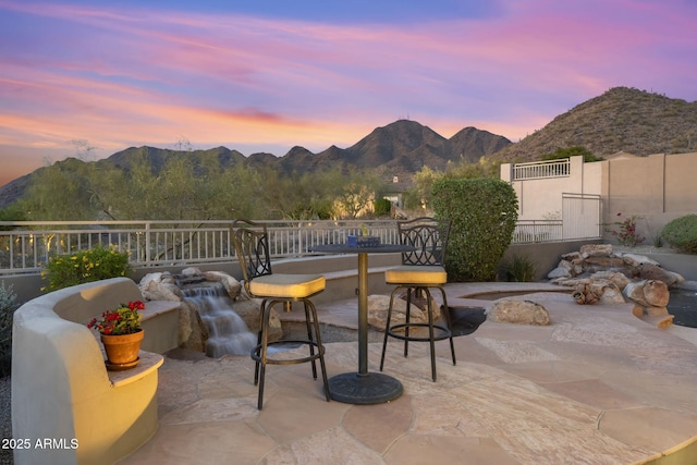 patio terrace at dusk with fence and a mountain view