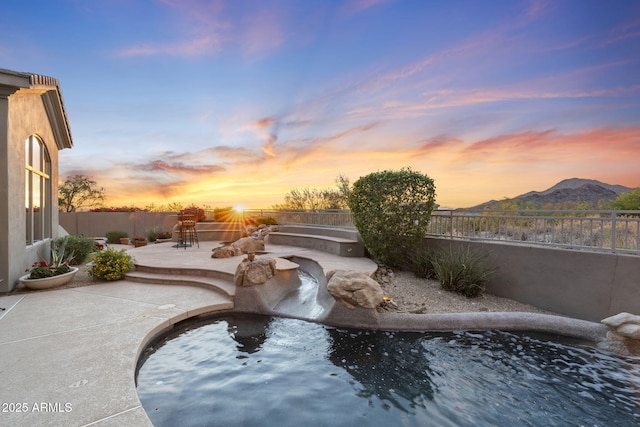 view of pool with a patio area, a mountain view, and a fenced backyard