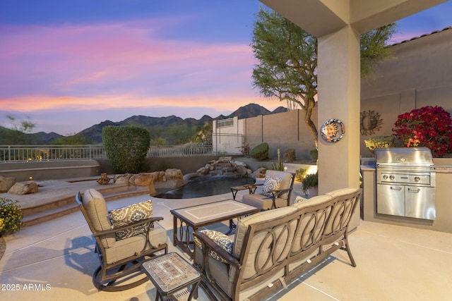 view of patio / terrace featuring a fenced backyard, an outdoor hangout area, area for grilling, and a mountain view