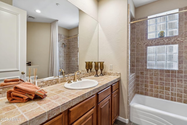 full bathroom with vanity, shower / tub combo with curtain, and visible vents