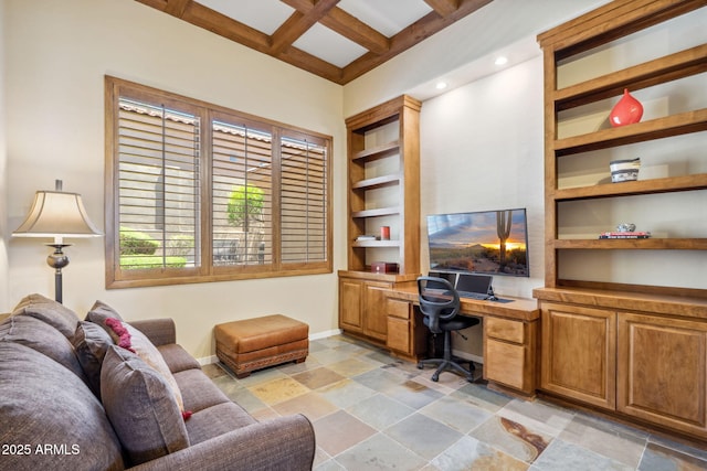 office area with stone finish floor, coffered ceiling, baseboards, built in desk, and beam ceiling