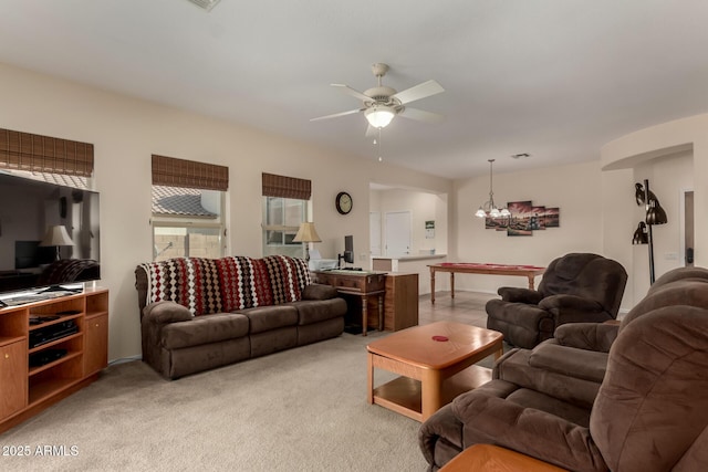 living room with light carpet and ceiling fan with notable chandelier