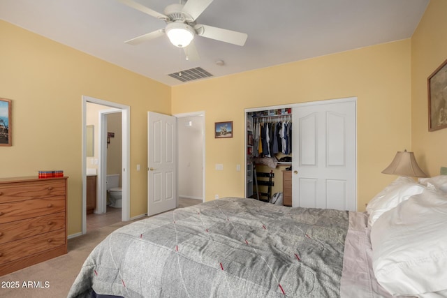 bedroom with ceiling fan, light colored carpet, connected bathroom, and a closet