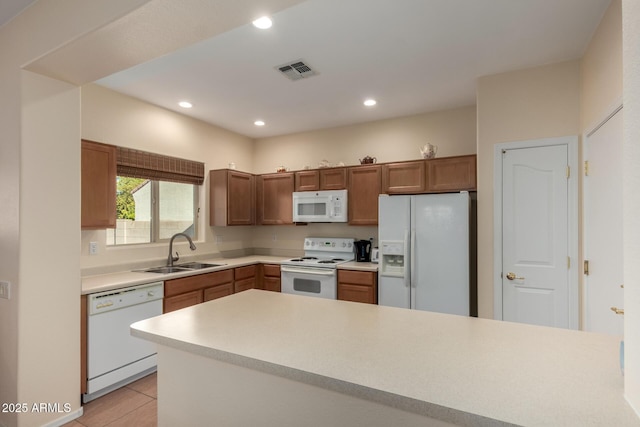 kitchen featuring sink, white appliances, and light tile patterned floors