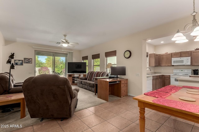 tiled living room with ceiling fan with notable chandelier and sink