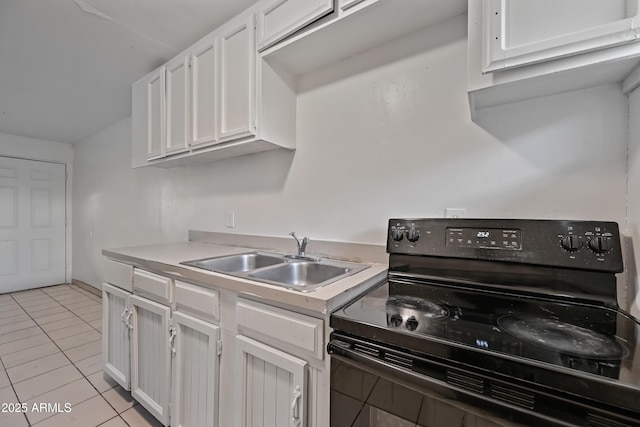 2237 E Taylor St, Phoenix, AZ 85006 - kitchen with black range with electric cooktop, light countertops, white cabinets, and light tile patterned flooring
