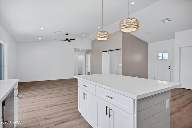 11509 W Langford Ct, Youngtown, AZ 85363 - kitchen with ceiling fan, a barn door, lofted ceiling, recessed lighting, and white cabinets