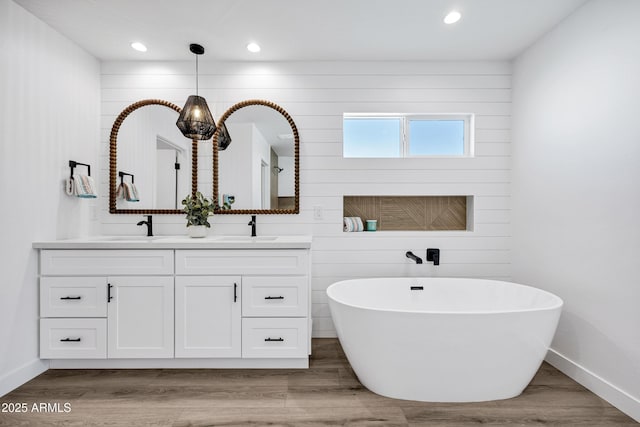11509 W Langford Ct, Youngtown, AZ 85363 - full bathroom featuring double vanity, a soaking tub, baseboards, recessed lighting, and wood finished floors